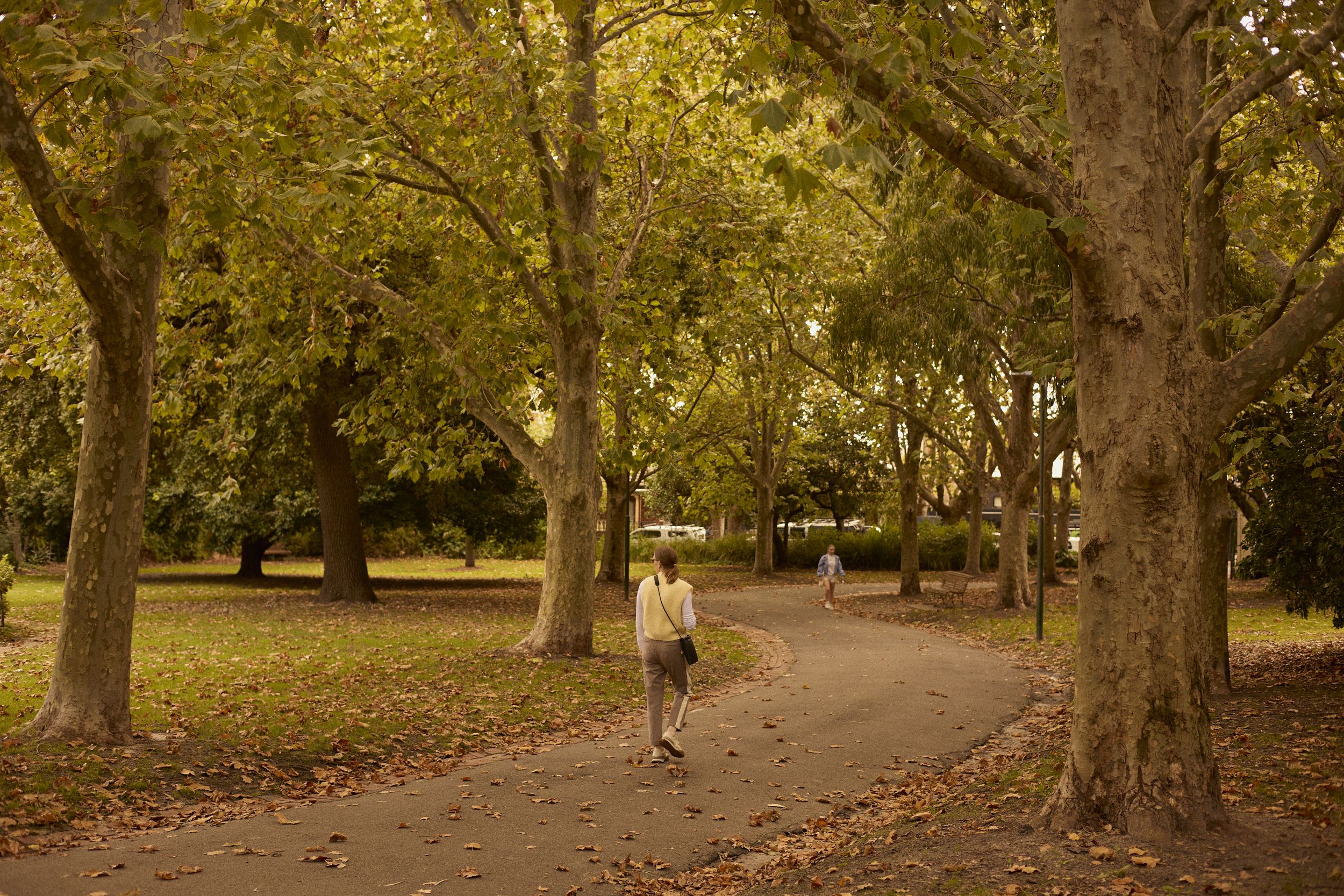 People walking down path in public park.