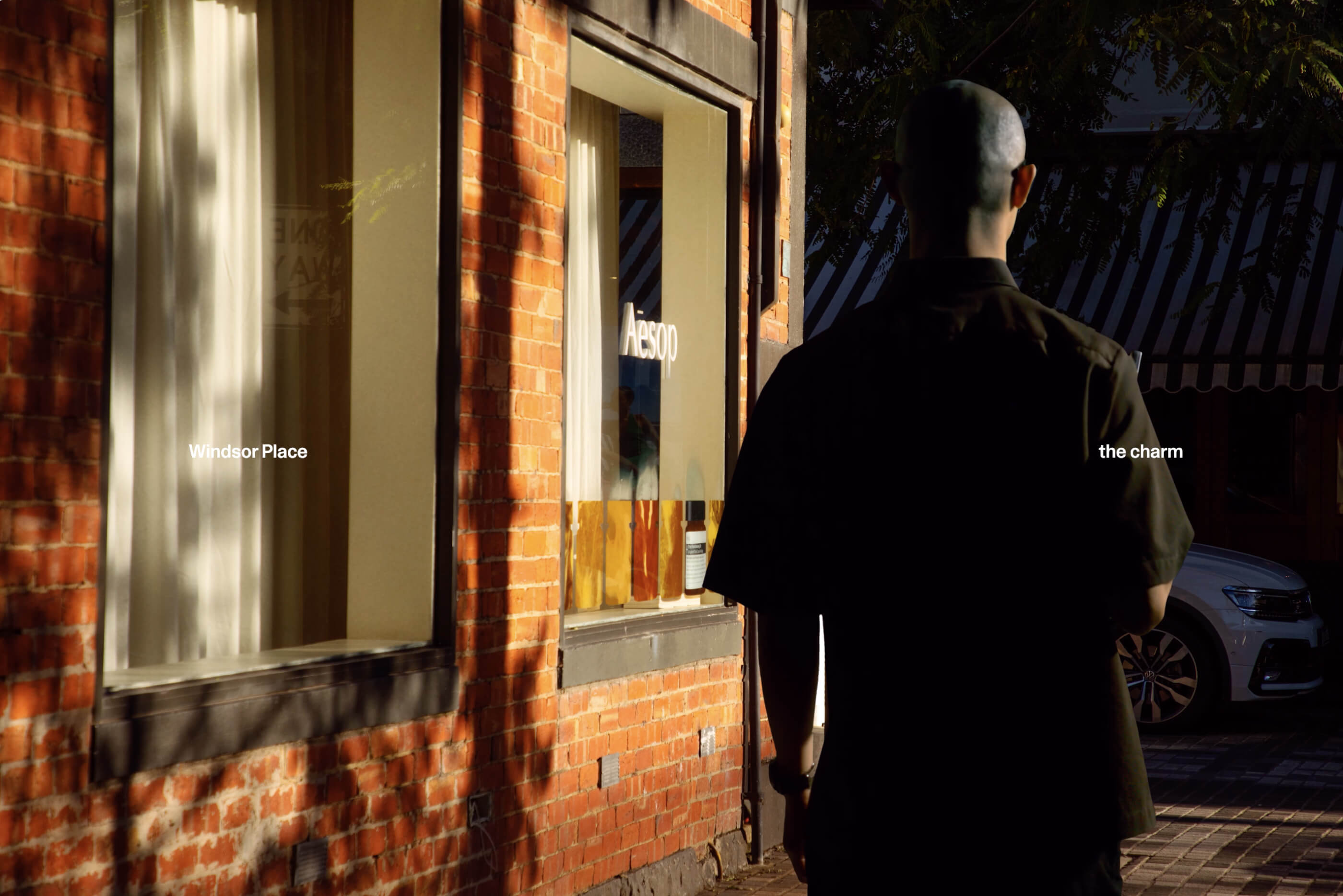 Person walking down a pathway next to a shop.